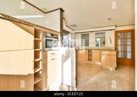 Une cuisine moderne lumineuse et spacieuse avec des armoires élégantes, des appareils élégants et une grande lumière naturelle, parfaite pour cuisiner et se divertir. Banque D'Images