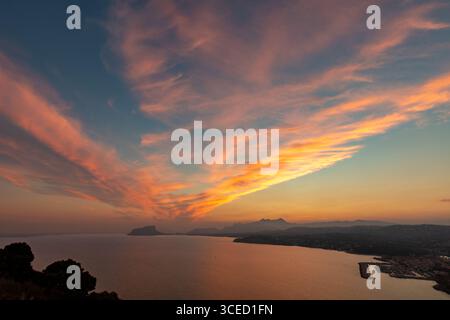 Un coucher de soleil à couper le souffle sur la mer Méditerranée à la Costa Blanca, capturant des couleurs vibrantes reflétant dans l'eau. Le paysage présente un calme Banque D'Images