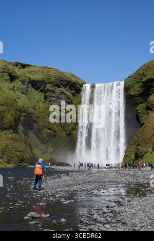 Islande, sud de l'Islande, Vik. Skógafoss, l'une des plus grandes cascades d'Islande, avec une chute de 60 mètres. Touristes devant la cascade. Banque D'Images