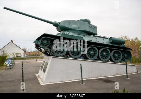 HORTOBAGY, HONGRIE 23 AVRIL 2022 Un char T 34 vert altéré repose sur un piédestal en pierre, légèrement incliné. L'arrière-plan présente un ciel nuageux et un Banque D'Images