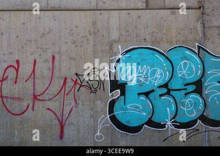 Graffiti art sous le pont sur le mur de béton avec des couleurs vibrantes Banque D'Images