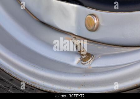 Tige de valve sur pneu de tracteur agricole. Pression des pneus, compactage du sol, entretien et réparation des équipements agricoles. Banque D'Images