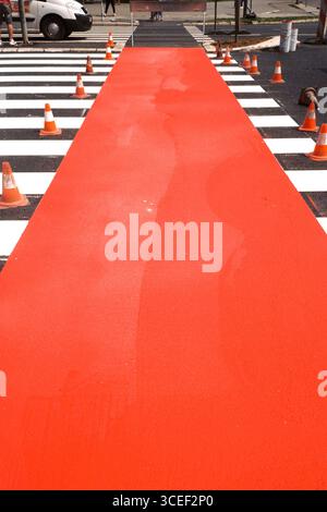Tapis rouge. Un passage fraîchement peint avec des cônes de circulation et un accent sur la piste cyclable rouge, photographié avec un film Olympus Mju et Kodak. Banque D'Images
