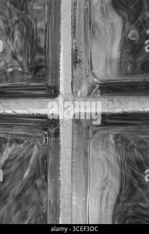 gros plan de la fenêtre de blocs de verre épais avec une pièce transversale dans les carrés ou rectangles recadrés du milieu réfléchissant la lumière créant des formes et des motifs Banque D'Images