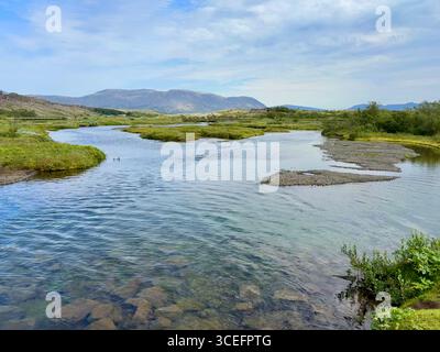 Le beau scenerary dans le parc national de Þingvellir (Thingvellir) regardant de l'autre côté de la rivière Oxara vers les montagnes un jour d'été. Banque D'Images