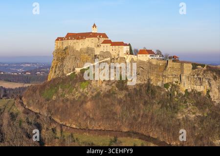 Vue aérienne du majestueux château de Riegersburg perché au sommet d'une roche volcanique, baigné dans la lueur chaude du soleil couchant, Riegersburg, Steiermark, Autriche. Banque D'Images