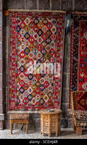 Turquie : tabourets en bois et tapis tissé à la main dans l'une des boutiques d'artisanat locales de Cappadoce, région historique en Anatolie centrale, parc national Goreme Banque D'Images