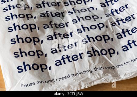 Un sac de transport en plastique Co-Op porte le message boutique, après boutique, après boutique ... me réutiliser jusqu'à ce que j'ai besoin de remplacement, puis échanger moi gratuitement. Banque D'Images