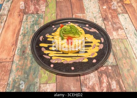 Version signature de Causa Limeña avec confit de canard, réduction de vin rouge et noix de pécan grillées Banque D'Images