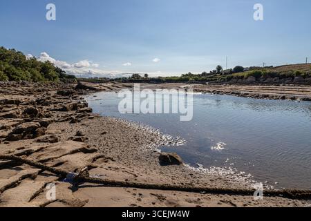 Santander, Espagne. La plage de la Maruca avec des bateaux échoués sur le sable à marée basse sous le soleil d'été Banque D'Images