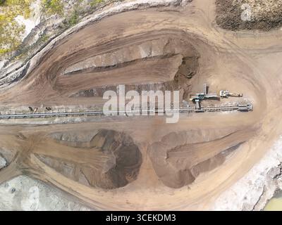 Vue aérienne de l'exploitation minière à ciel ouvert avec système de convoyeur – extraction industrielle et scène de terrassement Banque D'Images