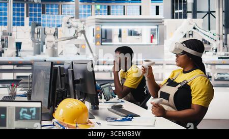 Technicien d'usine photovoltaïque utilisant un casque VR pour assembler des cellules solaires numériques, plaçant des panneaux solaires via des bras robotiques. Femme experte inspectant les machines de centrale solaire en utilisant la réalité virtuelle. Caméra B. Banque D'Images
