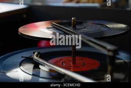 disques vinyles simples de 7 pouces empilés et joués sur une platine de disque de style ancien Banque D'Images