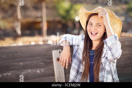 Jolie fille portant un chapeau de cowboy appréciant le Patch de citrouille sur un jour d'automne ensoleillé. Banque D'Images