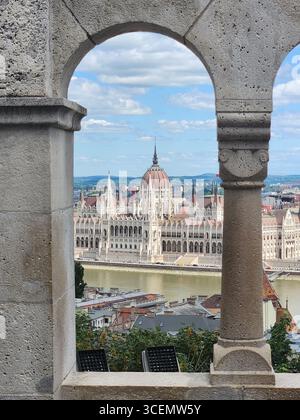 Bâtiment du Parlement hongrois vu à travers les arches du bastion des pêcheurs sur la colline du château Banque D'Images