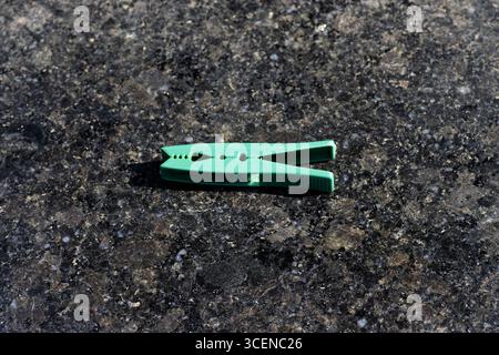 vêtements verts en plastique étoffe sur la chaussée noire Banque D'Images