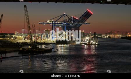 Vue aérienne de grues projetant de longues ombres sur les quais, la rivière reflétant les lumières de la ville comme des joyaux éparpillés, Savannah, Géorgie, États-Unis. Banque D'Images