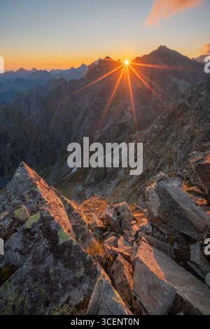 Vue aérienne du soleil éclatant sur des sommets montagneux accidentés, projetant de longues ombres sur le terrain rocheux, Vysoké Tatry, région de Prešov, Slovaquie. Banque D'Images