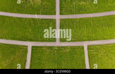 Vue aérienne de l'intersection de routes vides dans les champs d'herbe verte Banque D'Images