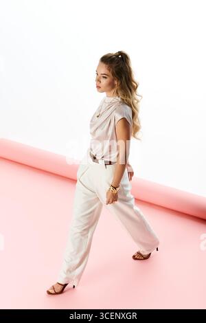 Jeune femme à la mode met en valeur son style moderne en toute confiance. Banque D'Images