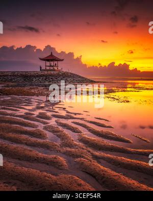 Alors que le soleil se lève à l'horizon, Pantai Sanur à Bali se transforme en un spectacle à couper le souffle. Banque D'Images
