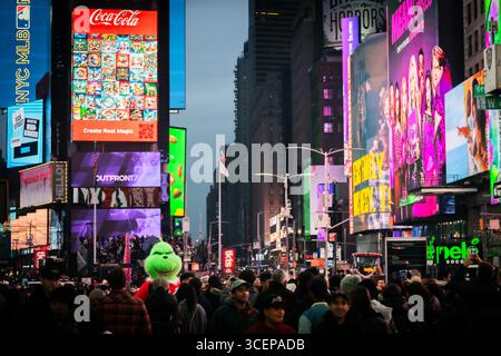 New York, États-Unis - 24 décembre 2023 : vue de Times Square palpitant avec des panneaux d'affichage vibrants et une foule dense sous le ciel crépusculaire, un spectacle d'énergie urbaine. Banque D'Images