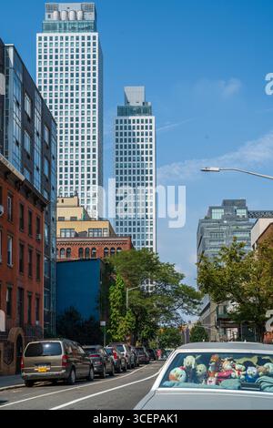 Brooklyn, États-Unis - 17 août 2025 : vue de gratte-ciels modernes étincelants perçant le ciel Azur, juxtaposés aux vieilles façades en briques des rues de Brooklyn. Banque D'Images