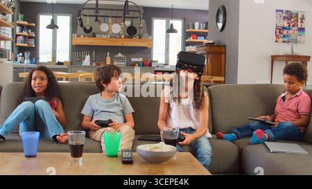 Les enfants jouent le jeu de l'ordinateur à l'aide de casque de réalité virtuelle Banque D'Images
