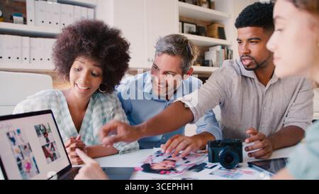 Équipe créative multiculturelle avec ordinateur portable Réunion pour examiner les mises en page Banque D'Images