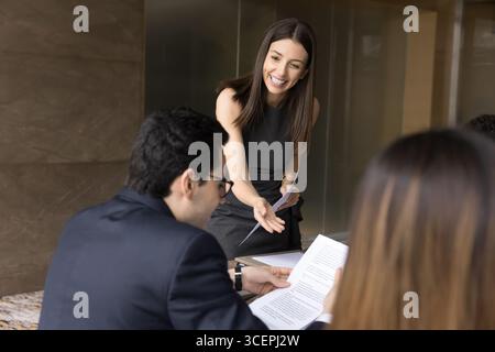 Conseillère juridique féminine de la génération y distribuant un document papier aux investisseurs Banque D'Images