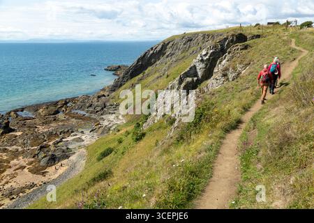 Marcheurs sur le sentier côtier Fife près d'Elie avec les falaises d'Earlsferry en arrière-plan, Fife, Écosse Banque D'Images