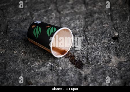 Berlin, Allemagne. 19 août 2025. Une tasse de café renversée repose sur l'asphalte. Crédit : Britta Pedersen/dpa/Alamy Live News Banque D'Images