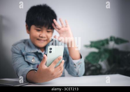 Communication numérique, technologie mobile, mode de vie des jeunes, connexion sociale et interaction en ligne moderne via des appareils. Jeune personne souriante wavi Banque D'Images