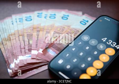Calculatrice placée sur les billets en euros sur le bureau Banque D'Images