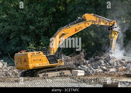 Herserange, France - vue sur une pelle sur chenilles jaunes CAT 374 pour la démolition d'un vieux viaduc routier sur un chantier de construction. Banque D'Images