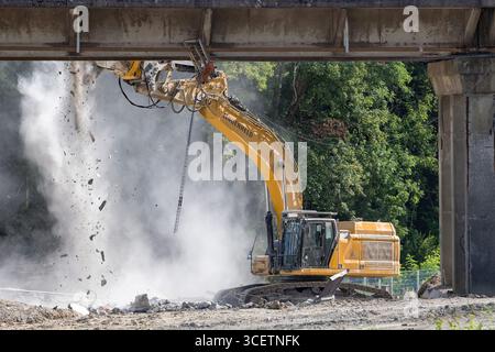 Herserange, France - vue sur une pelle sur chenilles jaunes CAT 352 pour la démolition d'un vieux viaduc routier sur un chantier de construction. Banque D'Images