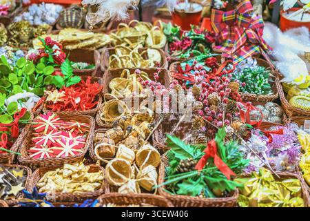 Décorations de Noël faites à la main en gros plan, vue de dessus. Assortiment de décorations de Noël faites à la main disposées dans des paniers en osier au marché festif. Concept de Banque D'Images