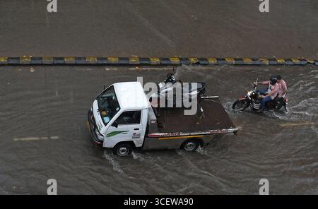 Mumbai, Maharashtra, Inde. 19 août 2025. Un véhicule et des motos sont vus se déplaçant dans une rue inondée causée par de fortes pluies à Mumbai. Le trafic sur la route, la ligne de chemin de fer ont été retardés en raison de fortes pluies et des inondations sur la route et la voie ferrée sont apparues. Les écoles et les collèges sont restés fermés et de nombreux bureaux ont permis à leurs employés de travailler à domicile. Alerte rouge a été émise par le Département météorologique indien (IMD) avertissant de précipitations extrêmement fortes jusqu'à mercredi, les citoyens ont été informés de ne pas s'aventurer dehors sauf si nécessaire. (Crédit image : © Ashish Vaishnav/SOPA images via ZUMA Press Wire) EDITORIAL US Banque D'Images