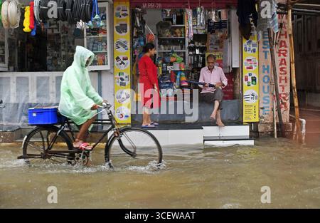 Mumbai, Maharashtra, Inde. 19 août 2025. Un commerçant montre un parapluie à une femme dans son magasin inondé d'eau causée par de fortes pluies à Mumbai. Le trafic sur la route, la ligne de chemin de fer ont été retardés en raison de fortes pluies et des inondations sur la route et la voie ferrée sont apparues. Les écoles et les collèges sont restés fermés et de nombreux bureaux ont permis à leurs employés de travailler à domicile. Alerte rouge a été émise par le Département météorologique indien (IMD) avertissant de précipitations extrêmement fortes jusqu'à mercredi, les citoyens ont été informés de ne pas s'aventurer dehors sauf si nécessaire. (Crédit image : © Ashish Vaishnav/SOPA images via ZUMA Press Wire) EDI Banque D'Images
