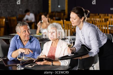 Femme serveur prenant la commande d'un couple âgé au restaurant Banque D'Images