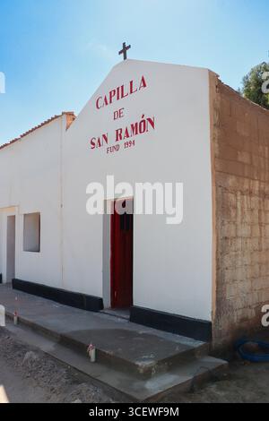 Chapelle Saint Raymond, fondée en 1994, sous un ciel bleu. Le petit bâtiment blanc avec sa porte rouge est un lieu de foi à Fiambala, Catamarca, argent Banque D'Images
