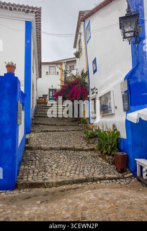 La rue étroite et colorée Travessa do Mestre Fernando, Óbidos, Portugal Banque D'Images