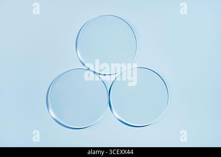 Trois boîtes de Petri vides sur fond bleu. Maquette pour échantillon de produit cosmétique Banque D'Images