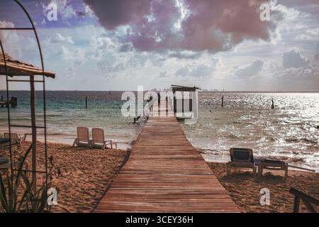 Isla mujeres, mexique 20 août 2025 : jetée en bois s'étendant dans la mer des caraïbes avec des touristes marchant vers l'océan à isla mujeres, mexique Banque D'Images