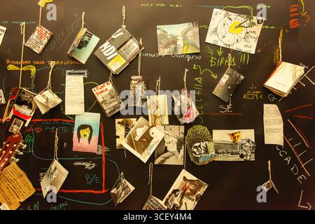 Cagliari, italie 19 août 2025 : des photos artistiques et des dessins suspendus à des cordes sur un tableau noir créent une installation artistique unique à cagliari, en italie Banque D'Images