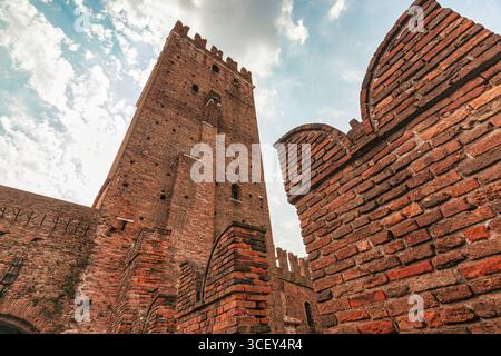 Vérone, italie 20 août 2025 : architecture médiévale de castelvecchio à vérone, italie, mettant en vedette la tour de briques emblématique et le pont contre un nuageux s. Banque D'Images