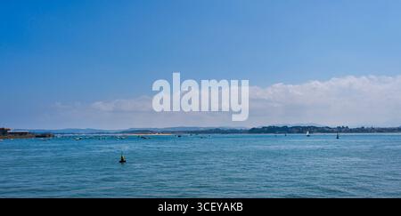 Vue panoramique sur la baie de Santander, en Cantabrie, avec la mer au premier plan et un ciel légèrement nuageux. Banque D'Images