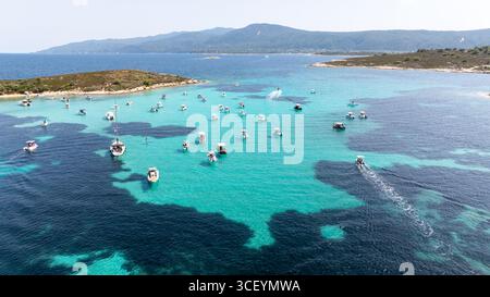 Bateaux ancrant dans les eaux turquoises claires de Vourvourou, en Grèce, créant une scène pittoresque Banque D'Images