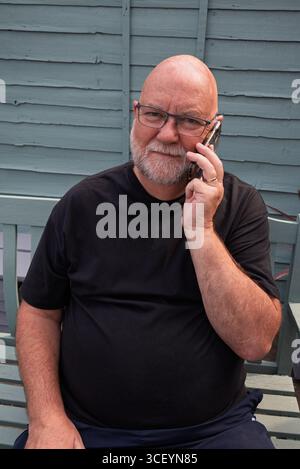 Vieil homme sur téléphone intelligent. Rester connecté avec ses amis et sa famille Banque D'Images
