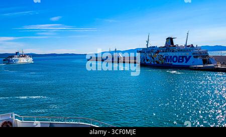 Trois ferries Moby Lines dans le port de Toscane. En arrière-plan - ciel bleu, au premier plan mer bleue brillante. 14 septembre 2025. Livourne, Italie. Banque D'Images